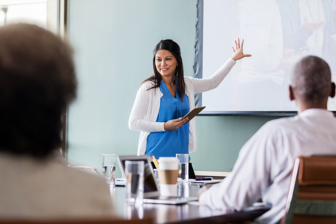 Female team member gives sales tips to colleagues during sales meeting